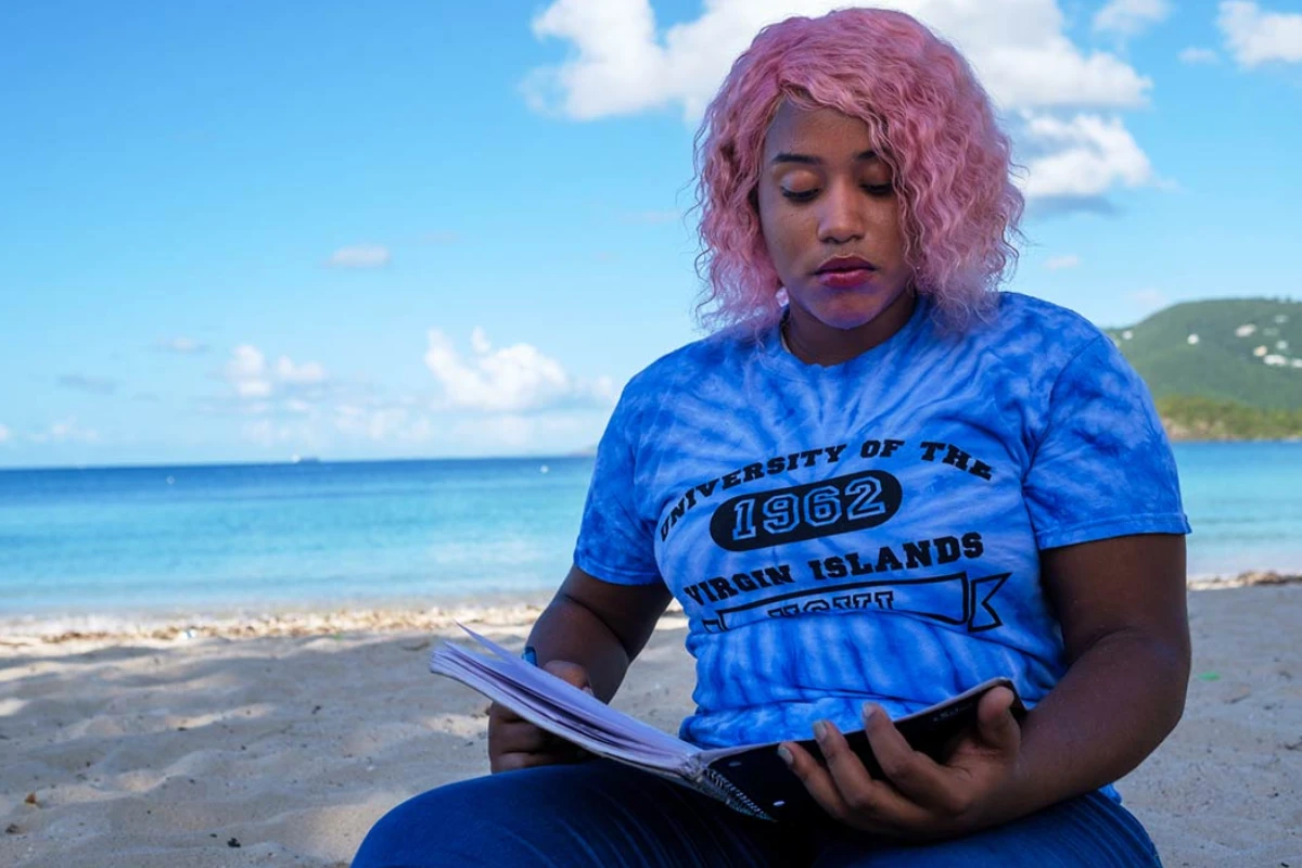 Student reading on Brewer's Bay Beach