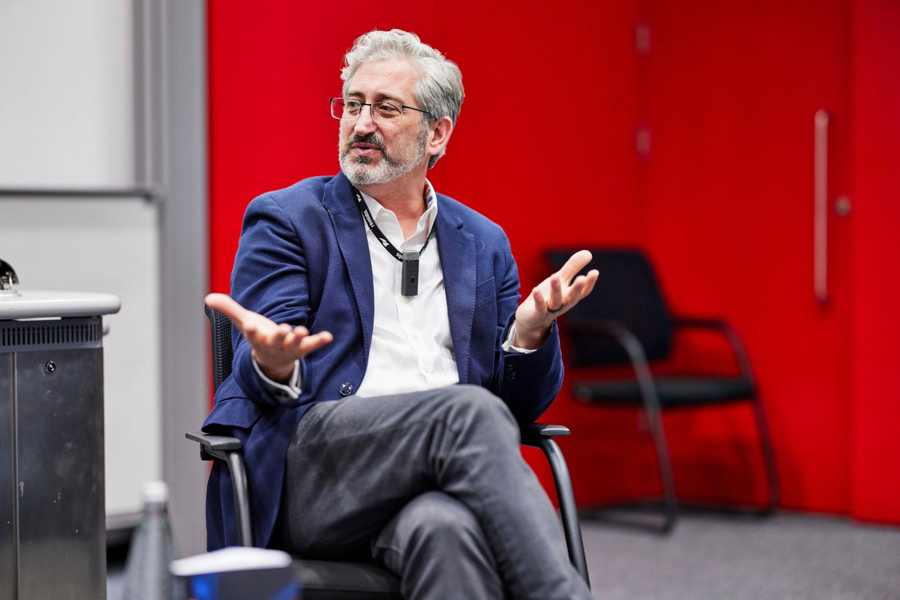 David Shrier gesturing with open hands while speaking during a presentation or panel discussion.