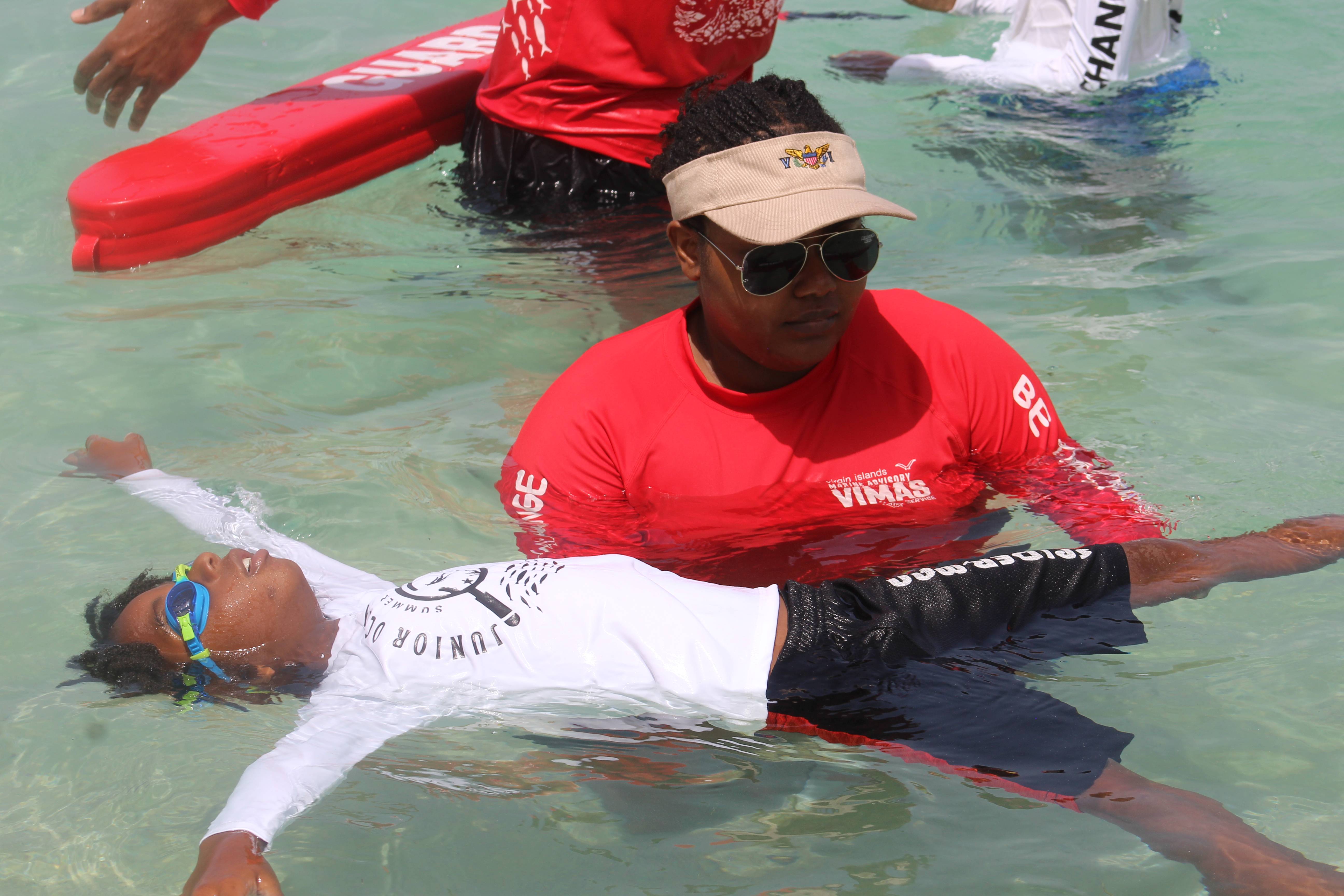 JOE staff helping a student master the back float skill 