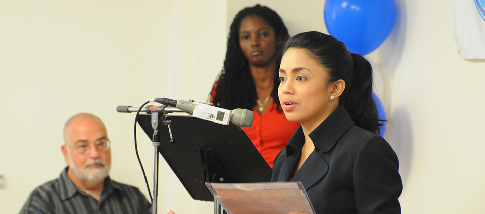 UVI graduate April Fale-Knight announces the launch of WUVI , while UVI communications Professor Dr. Alexander Randall (left) and UVI communications graduate Leslyn Tonge stand in the background.